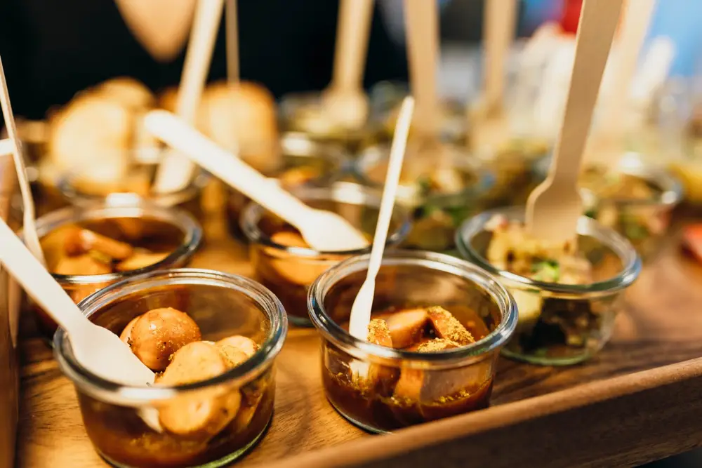 Currywurst mit Currypulver in Weckgläschen mit Holzgabeln